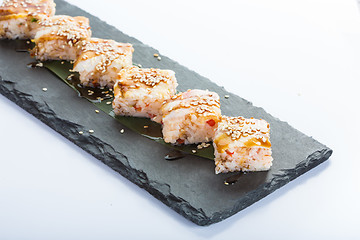 Image showing set of sushi on a slate square plate. 