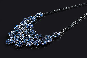 Image showing blue necklace on a black background. gems. 