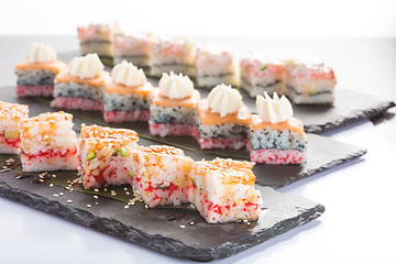 Image showing set of sushi on a slate square plate. 