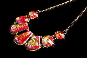 Image showing red necklace on a black background. gems. 