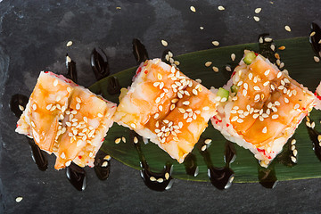 Image showing set of sushi on a slate square plate. 