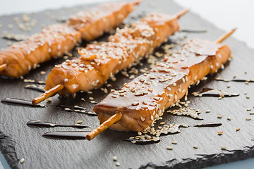 Image showing fish kebabs. on a black slate plate.