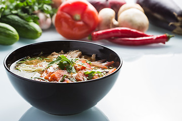 Image showing tomato soup in a black plate. 