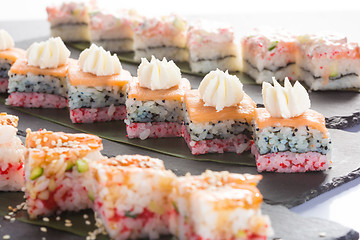 Image showing set of sushi on a slate square plate. 
