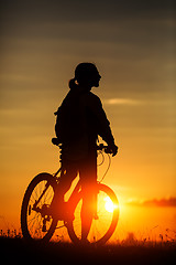 Image showing Silhouette of a bike on sky background during sunset
