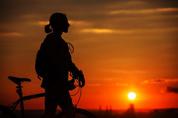 Image showing Silhouette of a bike on sky background during sunset