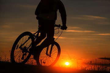 Image showing Silhouette of a bike on sky background during sunset