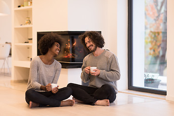 Image showing multiethnic couple  in front of fireplace