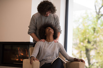 Image showing multiethnic couple hugging in front of fireplace