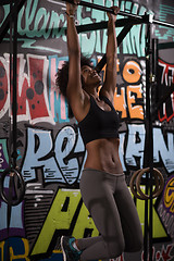 Image showing black woman doing pull ups