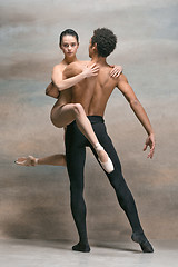 Image showing Couple of ballet dancers posing over gray background