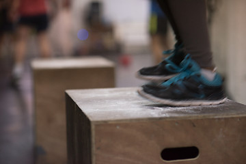 Image showing black woman is performing box jumps at gym