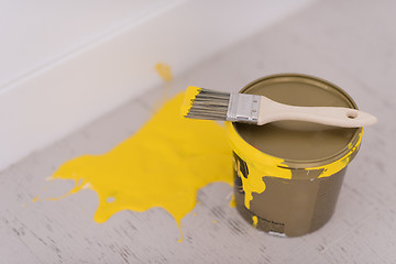 Image showing Yellow paint tin can with brush on top