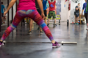 Image showing a group of people exercise with an empty bar