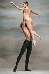 Image showing Couple of ballet dancers posing over gray background