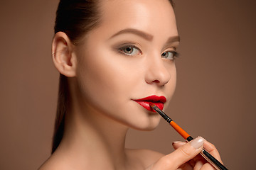 Image showing Beautiful female lips with make-up and brush