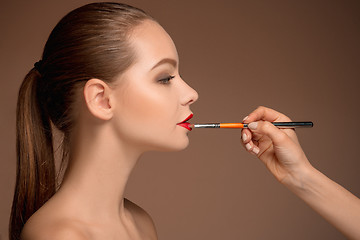 Image showing Beautiful female lips with make-up and brush