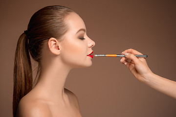 Image showing Beautiful female lips with make-up and brush