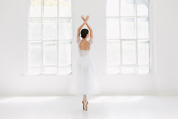 Image showing Young and incredibly beautiful ballerina is posing and dancing in a white studio