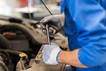 Image showing mechanic man with wrench repairing car at workshop