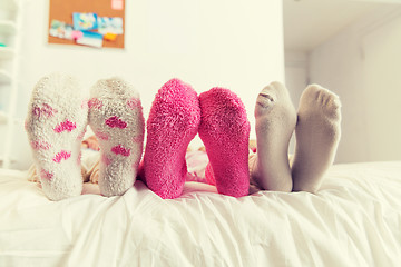 Image showing close up of women feet in socks on bed at home