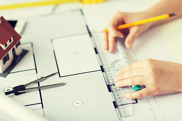 Image showing close up of hands with compass measuring blueprint