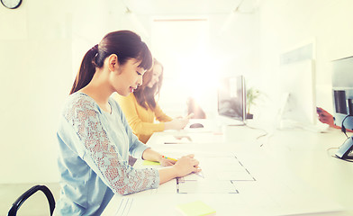 Image showing architect woman drawing on blueprint at office