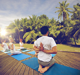 Image showing group of people making yoga exercises outdoors