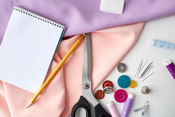 Image showing scissors, sewing tools, cloth and notepad