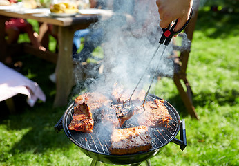 Image showing man cooking meat on barbecue grill at summer party