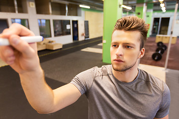 Image showing man writing note to whiteboard in gym