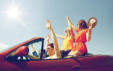 Image showing happy friends driving in cabriolet car at country