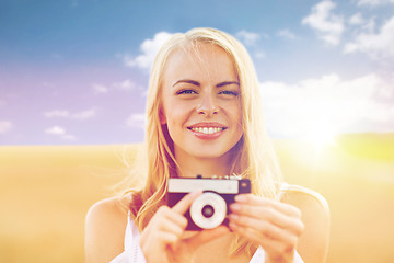 Image showing happy young woman with film camera outdoors