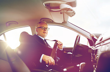 Image showing senior businessman fastening car seat belt