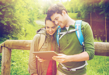 Image showing happy couple with backpacks and tablet pc outdoors