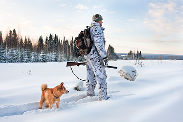 Image showing hunter with dog on the snowy road