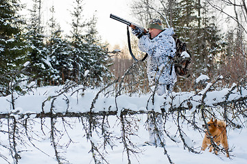 Image showing hunter shooting in snowy forest