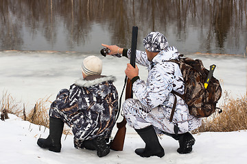 Image showing hunter shows his son where the prey