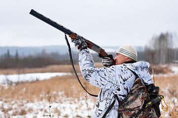 Image showing hunter shooting on the snowy field