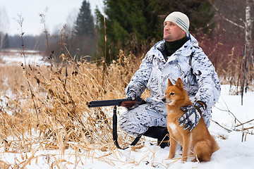 Image showing hunter with gun and dog in winter