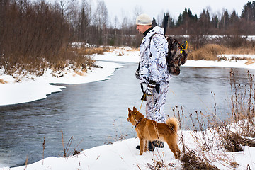 Image showing hunter with his dog on the river bank