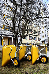 Image showing lot of empty new yellow garden wheelbarrows