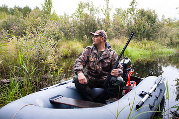 Image showing hunter with a gun in the boat