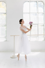 Image showing Young and incredibly beautiful ballerina is posing and dancing in a white studio