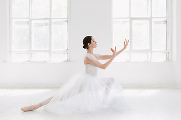 Image showing Young and incredibly beautiful ballerina is posing and dancing in a white studio