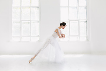 Image showing Young and incredibly beautiful ballerina is posing and dancing in a white studio