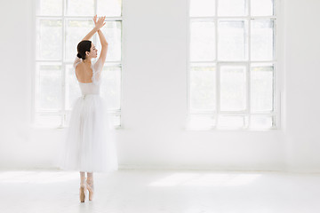 Image showing Young and incredibly beautiful ballerina is posing and dancing in a white studio