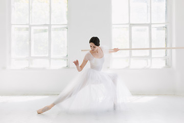 Image showing Young and incredibly beautiful ballerina is posing and dancing in a white studio