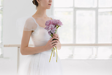 Image showing Young and incredibly beautiful ballerina is posing and dancing in a white studio