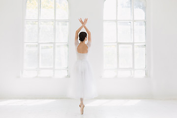 Image showing Young and incredibly beautiful ballerina is posing and dancing in a white studio